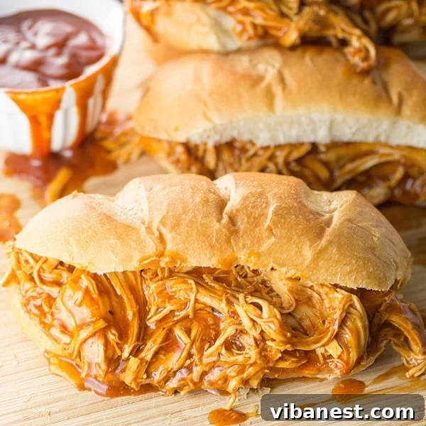 Italian BBQ Chicken Sandwiches plated Plated Slow Cooker Italian BBQ Chicken Sandwich with coleslaw and fruit