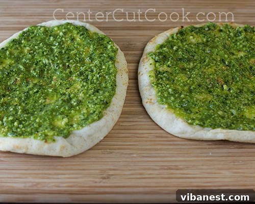 Pesto application on flatbread Spreading a thin layer of vibrant green pesto on flatbread