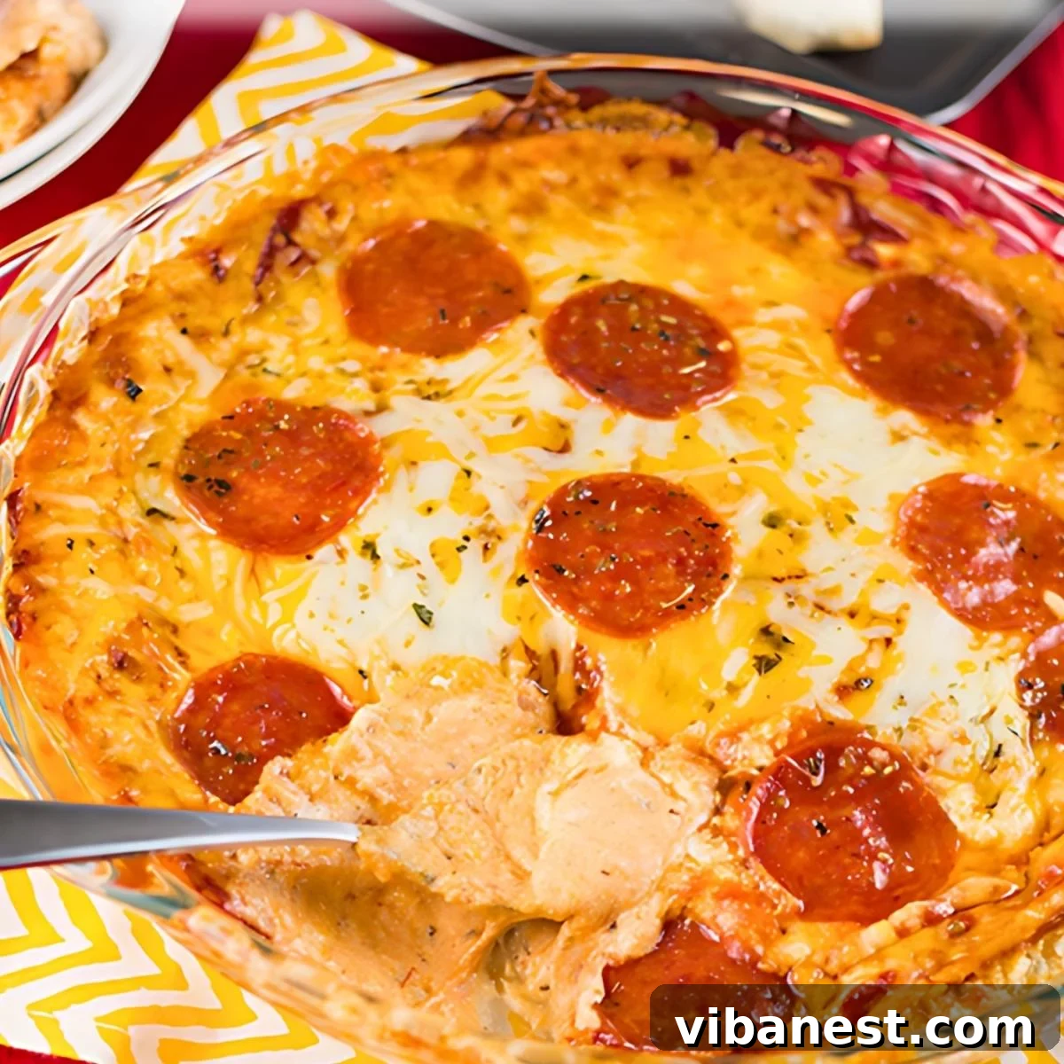 Everything Pizza Dip 2 Warm, bubbly cheesy pizza dip in a baking dish, ready to be served at a party.