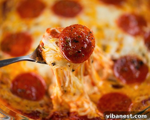 Variety of Pizza Dip Toppings Overhead shot of a baked pizza dip with a variety of toppings and melted cheese, ready for dipping.