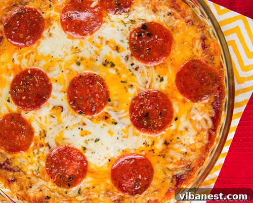Gooey Pizza Dip with Bread A bowl of pizza dip being scooped with a piece of toasted bread, showing the gooey cheese.