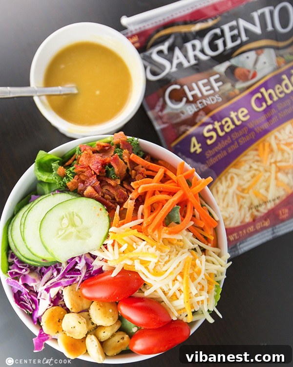 Ultimate Summer Salad with Dressing Ultimate Summer Salad with homemade honey mustard dressing being drizzled on top, showcasing fresh ingredients