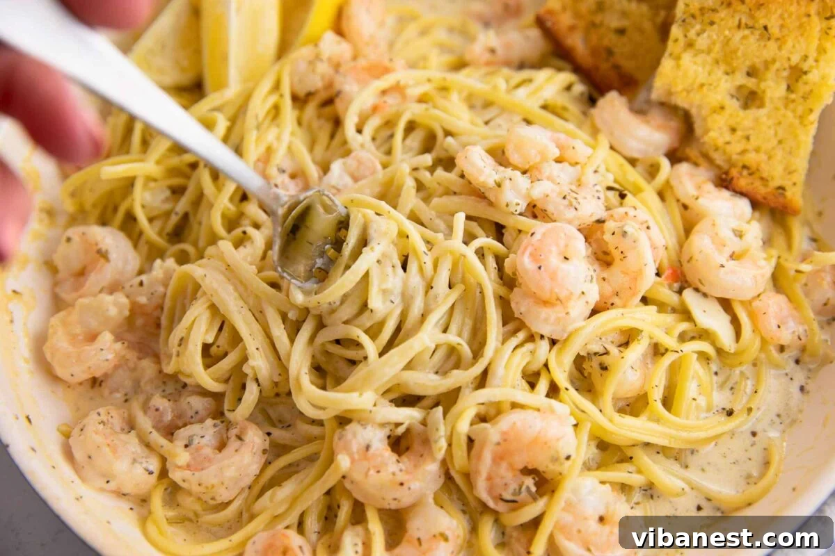 Lemon Garlic Shrimp Linguine 2 Creamy shrimp scampi pasta twirled gracefully on a fork, showcasing its rich texture and vibrant ingredients.