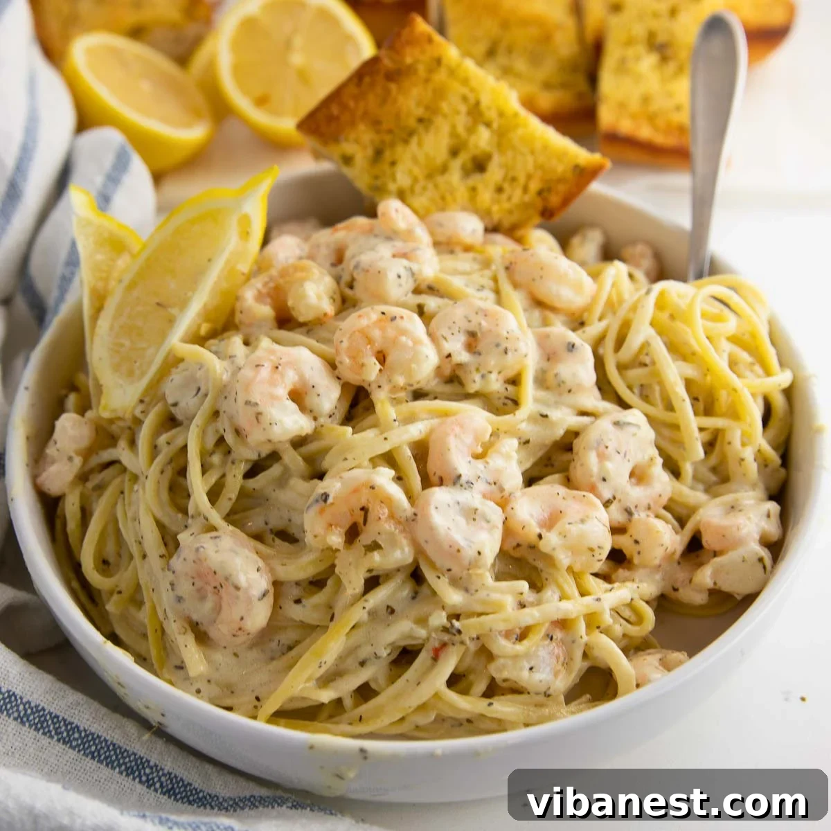 Lemon Garlic Shrimp Linguine 12 A rustic bowl filled with creamy shrimp scampi pasta, garnished with fresh parsley and served alongside crusty garlic bread, inviting a delightful meal.