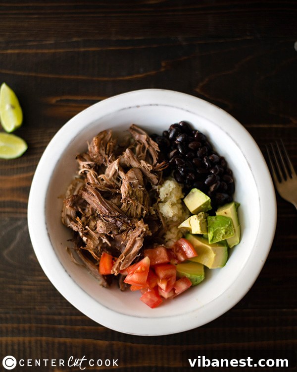 Slow Cooker Carnitas Burrito Bowl Close-up of crispy slow cooker carnitas in a bowl with fresh lime and cilantro