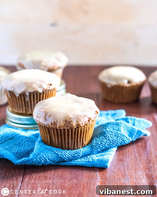 Homemade Zucchini Muffins with Peanut Butter Glaze A close-up shot of two perfectly baked zucchini muffins, one elegantly topped with a creamy white chocolate peanut butter glaze, ready to be enjoyed.