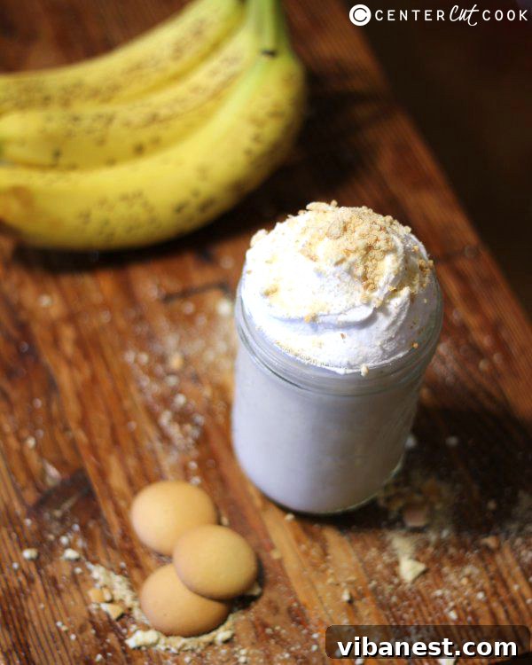 Banana Cream Pie Smoothie Detailed View Close-up of a Banana Cream Pie Smoothie in a glass with a straw, showing its creamy texture and garnish.