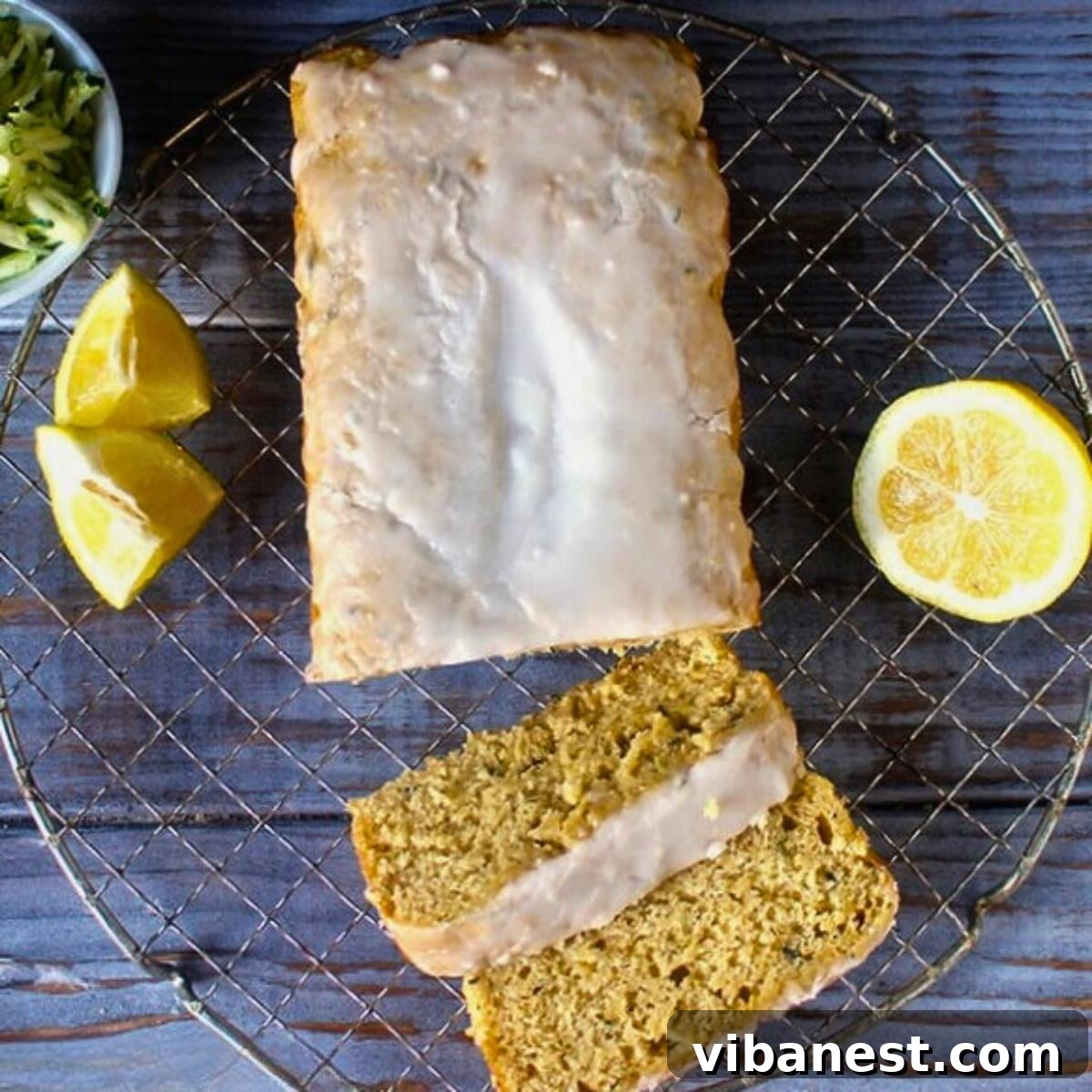 Bright Lemon Zucchini Loaf 4 A freshly baked loaf of golden lemon zucchini bread cooling gracefully on a wire rack, with vibrant lemon slices artfully arranged in the background, hinting at its citrusy essence.