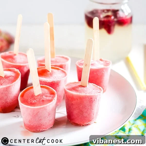 A batch of homemade strawberry lemonade ice pops perfectly set in their molds, ready to be enjoyed