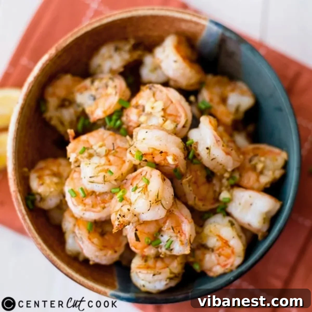 Buttery Garlic Parmesan Shrimp 2 Close-up of golden-brown garlic parmesan shrimp arranged on a baking sheet, garnished with fresh parsley.