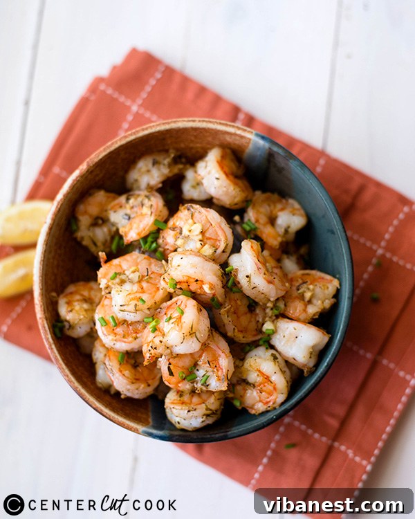 parmesan-roasted-shrimp-3.jpg A dish of garlic parmesan shrimp ready to be served, with a vibrant garnish of fresh parsley.