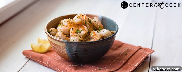 parmesan-roasted-shrimp-1.jpg A close-up shot of perfectly cooked garlic parmesan shrimp with fresh parsley and lemon wedges.