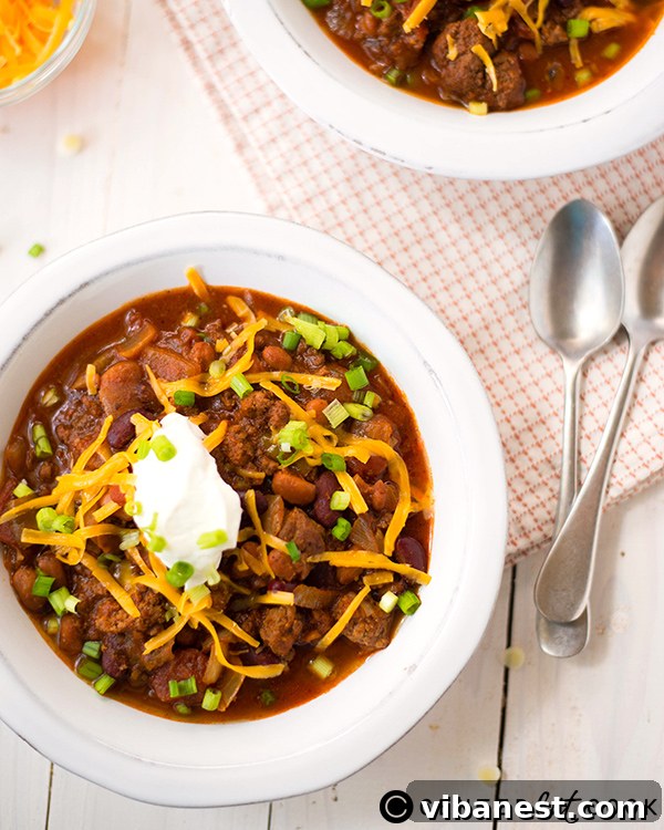 Close-up of slow cooker chili simmering with a spoon, highlighting its rich texture and colors