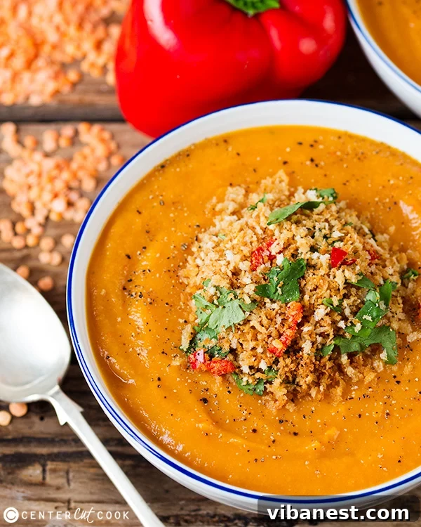 Close-up of a rustic wooden bowl filled with creamy lentil vegetable soup, ready to be served.