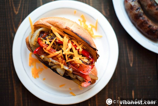 Gourmet Bratwurst Hot Dogs on a Plate Juicy beer-boiled bratwurst hot dogs served in hoagie rolls with caramelized onions and peppers, ready for a gourmet meal.