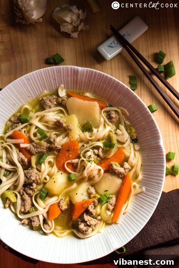 Close-up view of Asian Chicken Noodle Soup with vibrant vegetables and savory broth