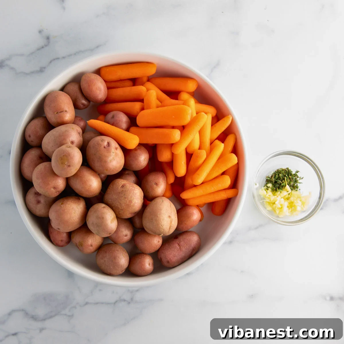 Golden Garlic Roasted Potatoes and Carrots 5 A collection of ingredients for roasted baby potatoes and carrots, including fresh baby potatoes, baby carrots, olive oil, garlic, thyme, salt, and pepper.