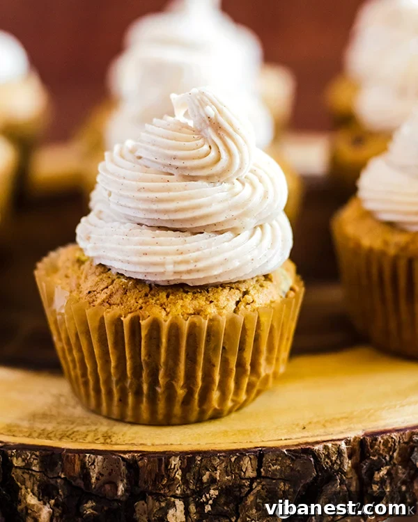 Close-up of a perfectly frosted pumpkin spice cupcake, showing the soft cake and creamy frosting