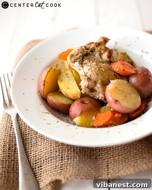 Close-up of roasted rosemary chicken and carrots on a pan
