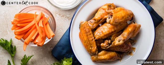baked-buffalo-wings-1.jpg baked chicken wings fresh out of the oven, on a platter served with ranch, carrots, and celery sticks