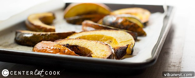 Golden roasted acorn squash slices beautifully arranged on a baking sheet, ready to be served