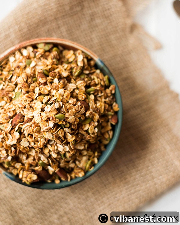pumpkin-spice-granola-2.jpg A bowl of pumpkin spice granola with a spoon, ready to be enjoyed