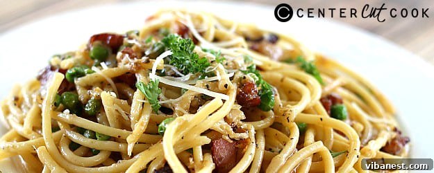 bucatini-carbonara-1.jpg A vibrant shot of Bucatini Carbonara, emphasizing the fresh herbs and rich texture, ready to be served.