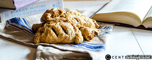 Delicious golden brown pumpkin hand pies arranged beautifully on a rustic wooden surface, hinting at their warm, inviting filling.