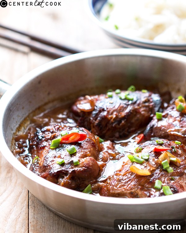Close-up of golden brown sticky ginger chicken thighs in a pan