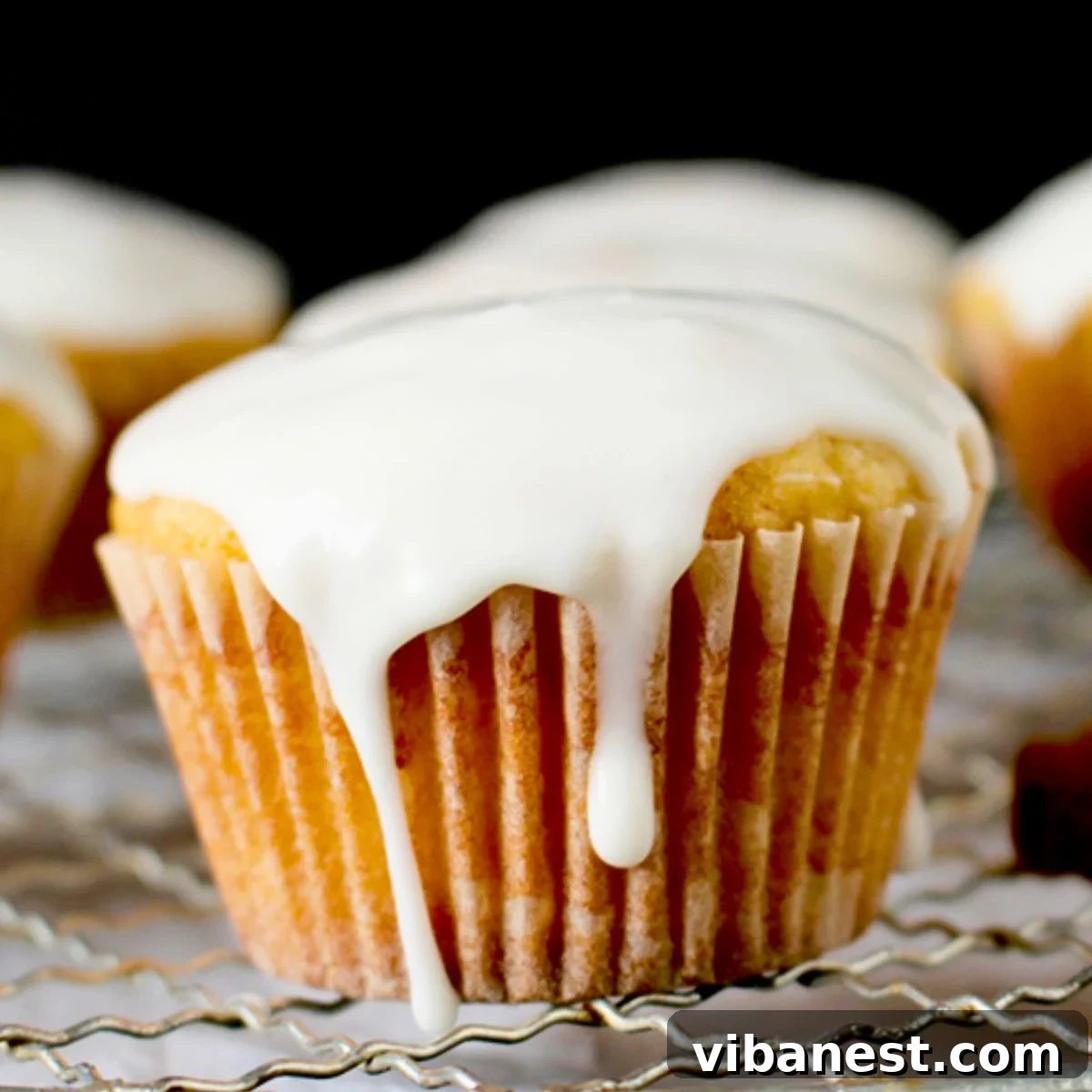 Festive Eggnog Muffins 2 eggnog muffins with eggnog glaze, dusted with nutmeg, on a festive holiday table setting