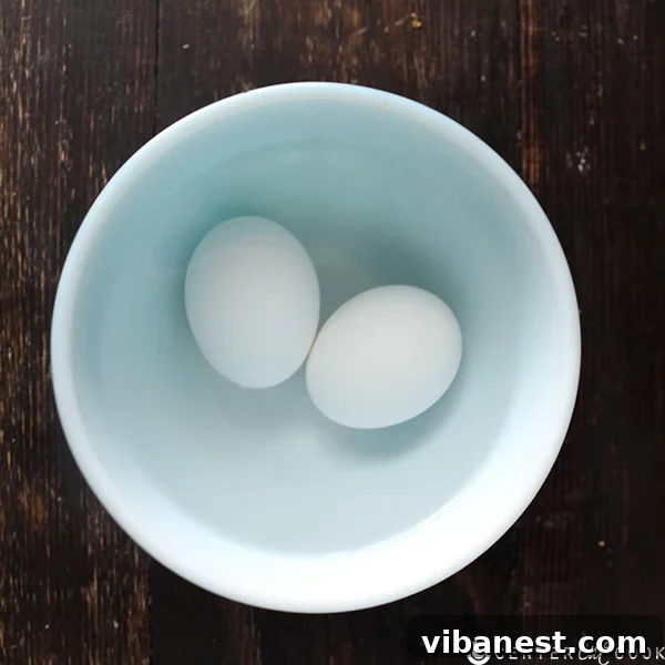 cookie_baking_tips_eggs.jpg Close-up of three brown eggs in a bowl of warm water, a quick method for bringing them to room temperature for baking.