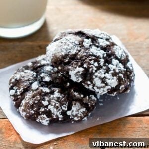 stack of cakey chocolate crinkle cookies coated in powdered sugar on a plate