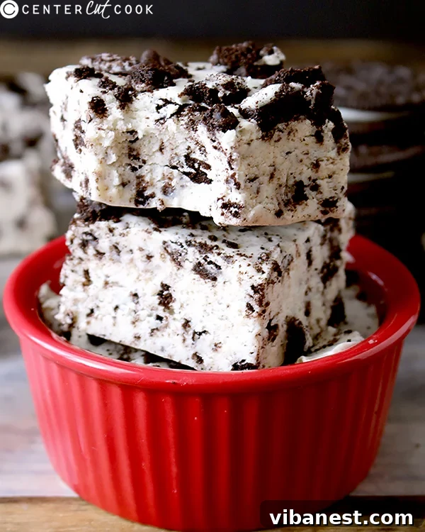 Decadent Oreo Cheesecake Fudge 2 Two pieces of creamy Oreo Cheesecake Fudge garnished with crushed Oreos on a white plate