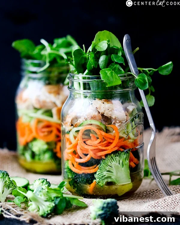how-to-make-a-mason-jar-salad-2.jpg Two vibrant mason jar salads showcasing colorful layers