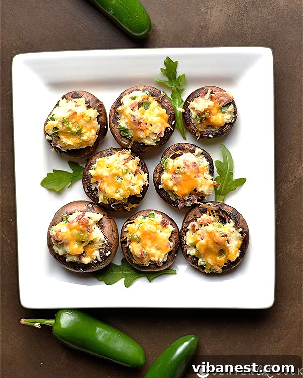 Close-up of perfectly baked Jalapeño Popper Stuffed Mushrooms, glistening with melted cheese