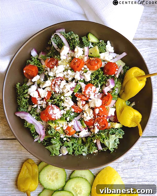 Close-up shot of the vibrant chopped kale Greek salad showing feta, olives, and tomatoes.
