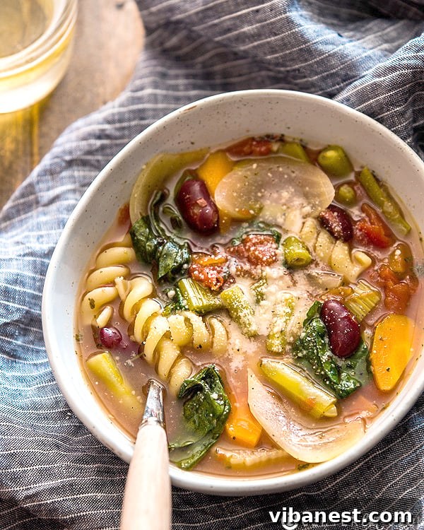 Close-up shot of slow cooker minestrone soup simmering, showing colorful vegetables and beans