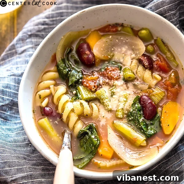 A serving of slow cooker minestrone soup topped with grated Parmesan cheese, ready to eat