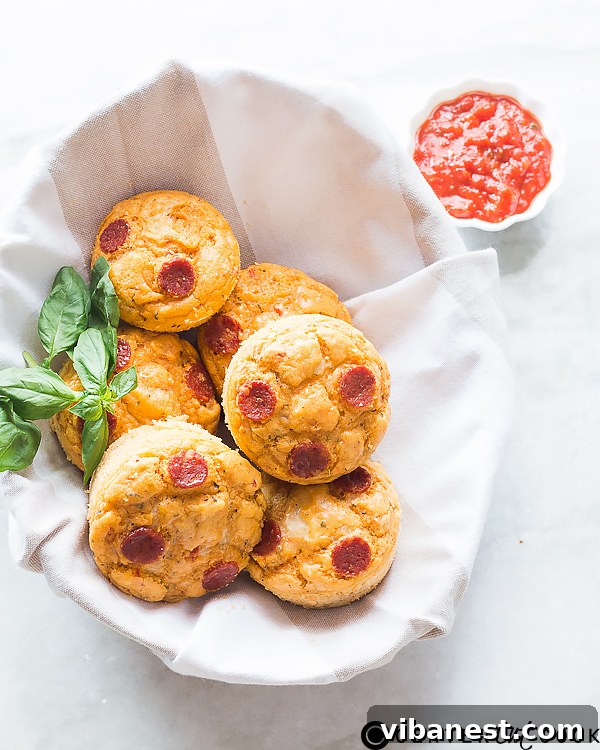 pepperoni-cheese-pizza-muffins-2.jpg Close-up of a pepperoni cheese pizza muffin, showing melted cheese and visible pepperoni pieces