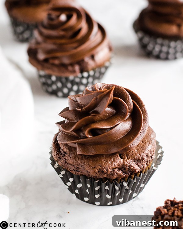 Beautifully frosted Chocolate Cheesecake Cupcakes on a rustic wooden surface