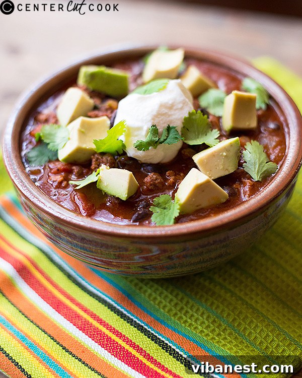 Close-up of a bowl of taco soup with a spoon, showing rich ingredients