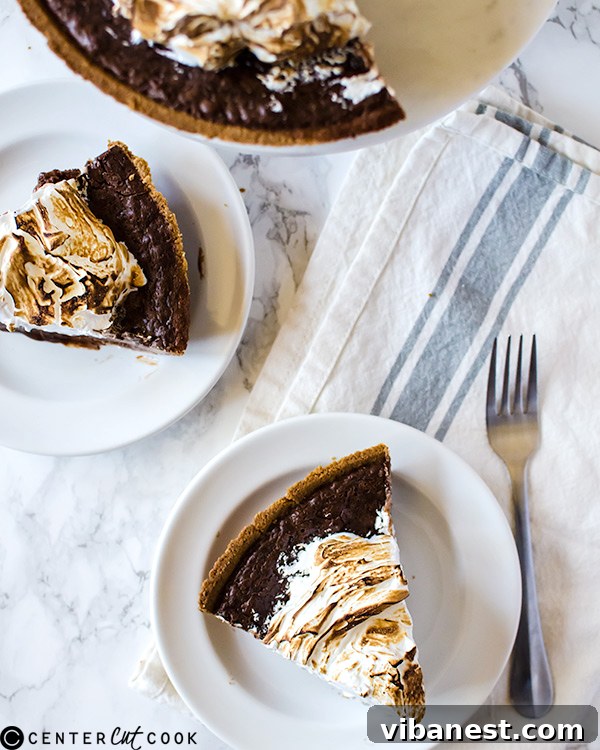 Close-up of a s'mores pie slice, showing layers of crust, chocolate, and marshmallow