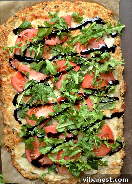 Close-up of a slice of Caprese Quinoa Pizza showing crispy crust and fresh toppings
