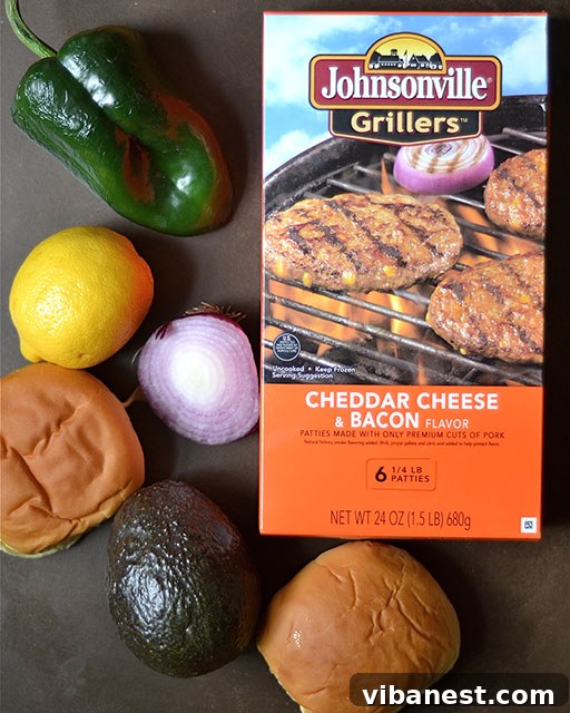 Johnsonville Sausage Burgers with Grilled Poblano Peppers and Guacamole Close-up of three grilled Johnsonville sausage burgers topped with melted cheese, bacon, and grilled poblano peppers on hamburger buns, served on a wooden board.