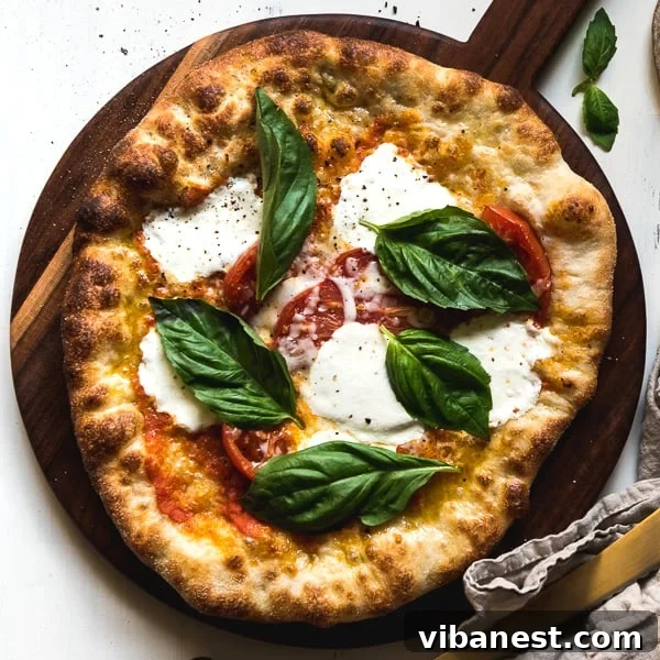 A whole, freshly baked Margherita pizza, garnished with fresh basil leaves