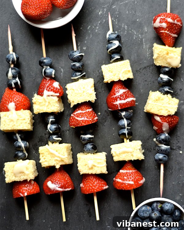 Children's hands assembling Blueberry Strawberry Shortcake Kabobs
