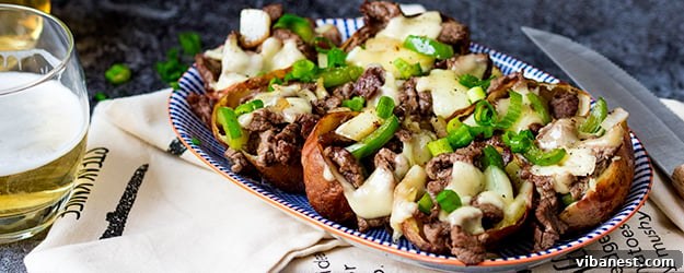 Crispy golden cheesesteak potato skins with melted cheese and fresh scallions, ready to be served