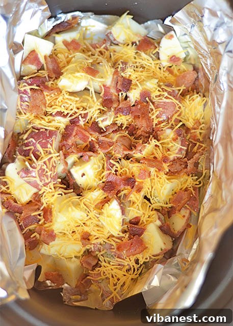 Close-up of perfectly cooked Slow Cooker Cheddar Bacon Ranch Potatoes with melted cheese and visible bacon bits.