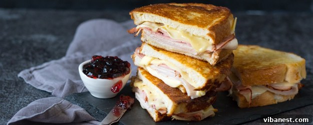Delicious Monte Cristo Sandwich with powdered sugar and jelly on a plate
