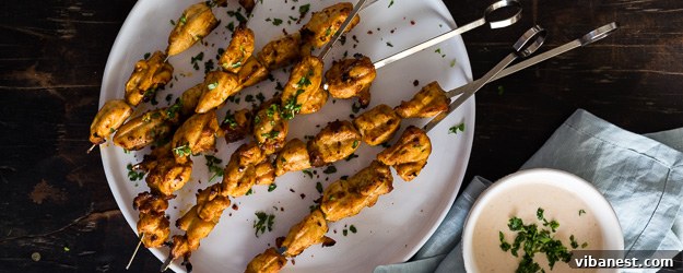 Flavorful Chipotle Chicken Kabobs on a platter with sauce